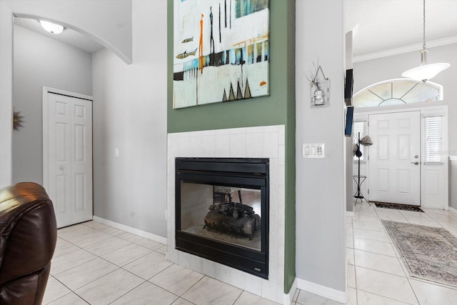 foyer entrance with baseboards, arched walkways, a glass covered fireplace, tile patterned floors, and crown molding