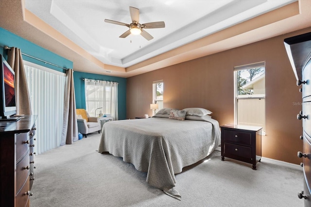 bedroom featuring carpet floors, ceiling fan, baseboards, and a raised ceiling