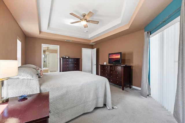 bedroom featuring a raised ceiling, light colored carpet, ceiling fan, and visible vents