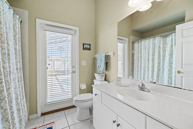 full bath featuring toilet, vanity, a wealth of natural light, and tile patterned floors