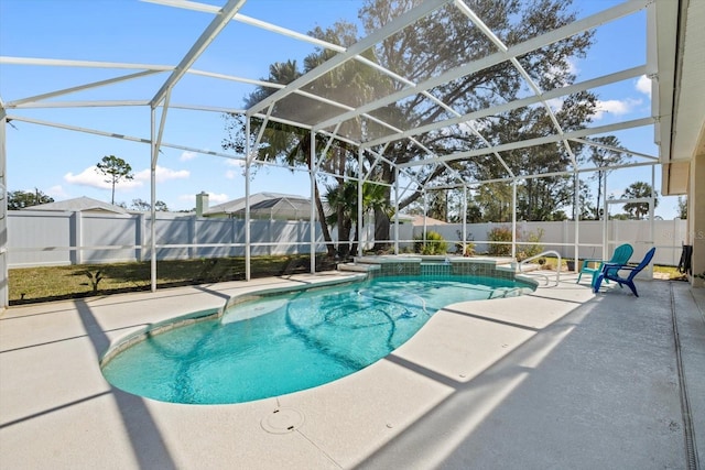 view of pool featuring a lanai, a patio area, a pool with connected hot tub, and a fenced backyard