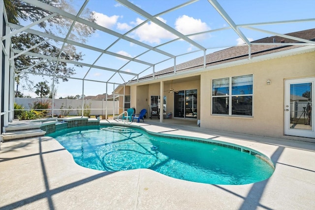 view of pool with a patio, glass enclosure, a pool with connected hot tub, and a ceiling fan