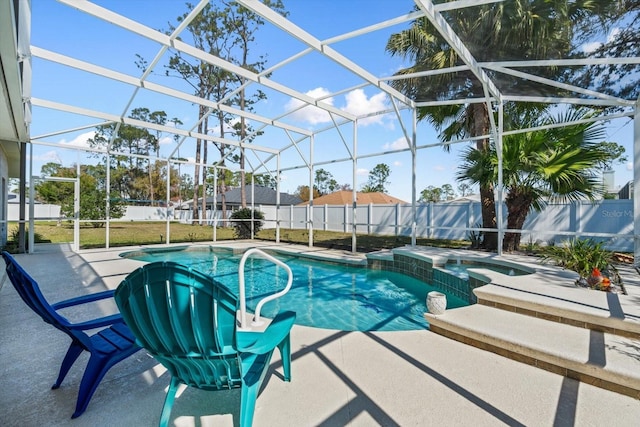 view of swimming pool featuring a patio area, a fenced backyard, a pool with connected hot tub, and a lanai