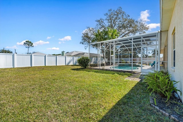 view of yard featuring a fenced in pool, glass enclosure, and a fenced backyard