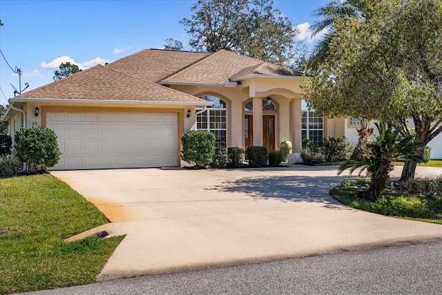 view of front of property with driveway, an attached garage, a shingled roof, and stucco siding