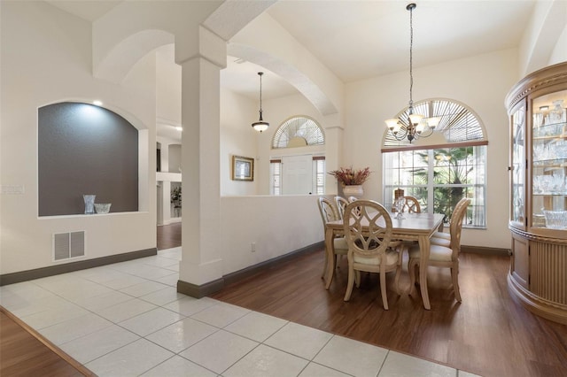 dining area featuring visible vents, baseboards, wood finished floors, and a chandelier