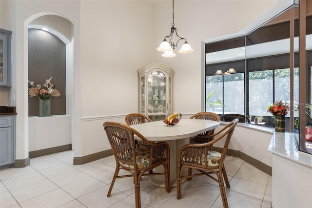 dining area with light tile patterned floors, baseboards, and a chandelier