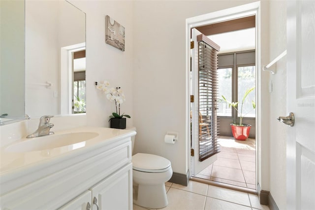 bathroom with tile patterned floors, plenty of natural light, toilet, and vanity