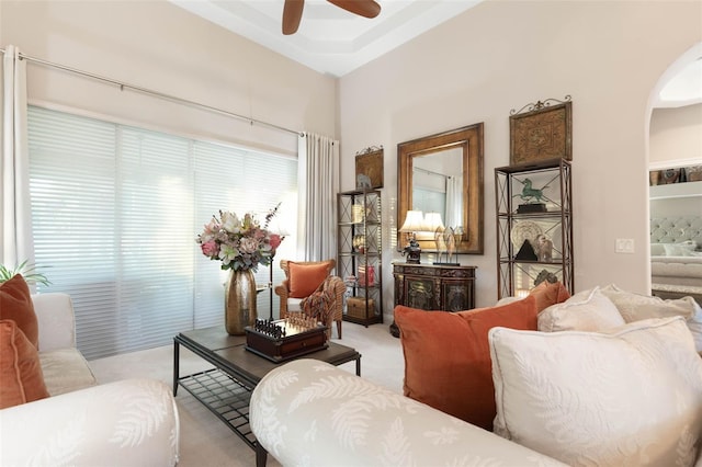 living area featuring light carpet and ceiling fan