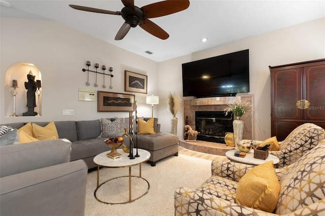 living area with ceiling fan, a fireplace, wood finished floors, and visible vents