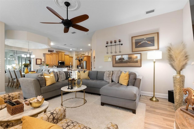 living area featuring visible vents, baseboards, ceiling fan with notable chandelier, light wood-type flooring, and recessed lighting