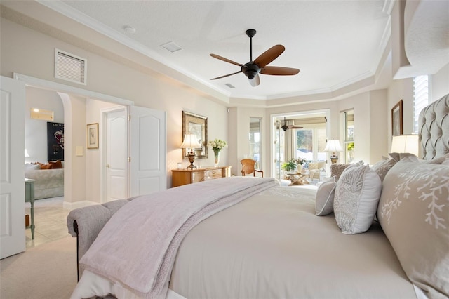 carpeted bedroom featuring visible vents, a ceiling fan, ornamental molding, tile patterned floors, and a raised ceiling