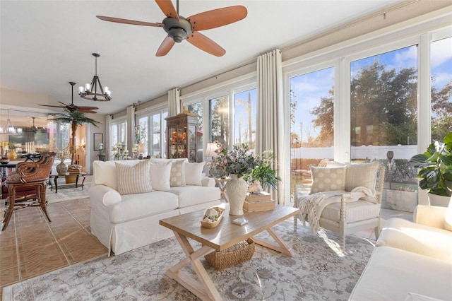 sunroom featuring ceiling fan with notable chandelier