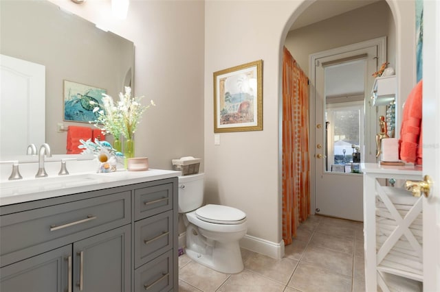 bathroom with toilet, tile patterned flooring, baseboards, and vanity