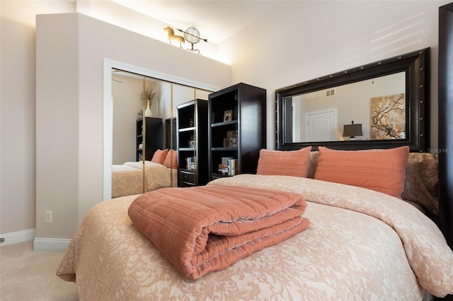 bedroom with baseboards, carpet, visible vents, and a closet