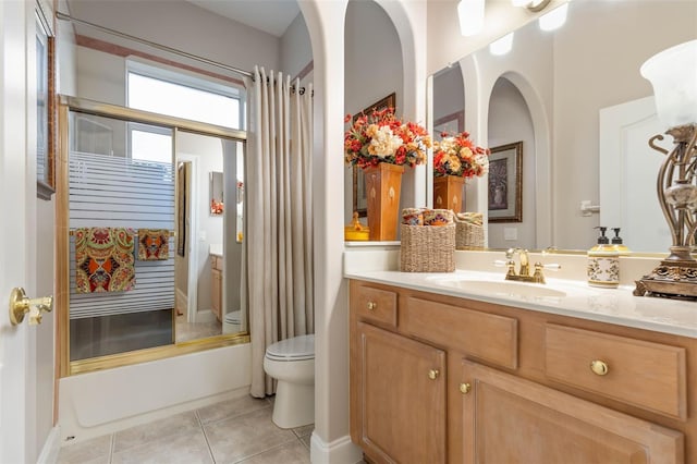 bathroom featuring vanity, tile patterned flooring, toilet, and shower / tub combo with curtain