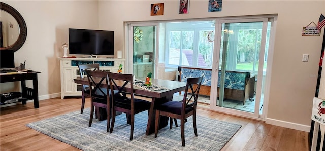 dining space with light wood-style flooring and baseboards