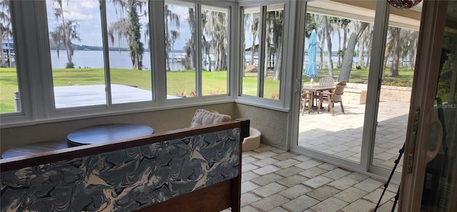 sunroom / solarium featuring a water view