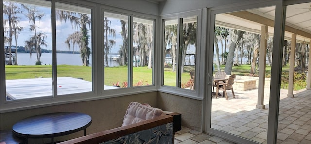 sunroom featuring a water view and a wealth of natural light