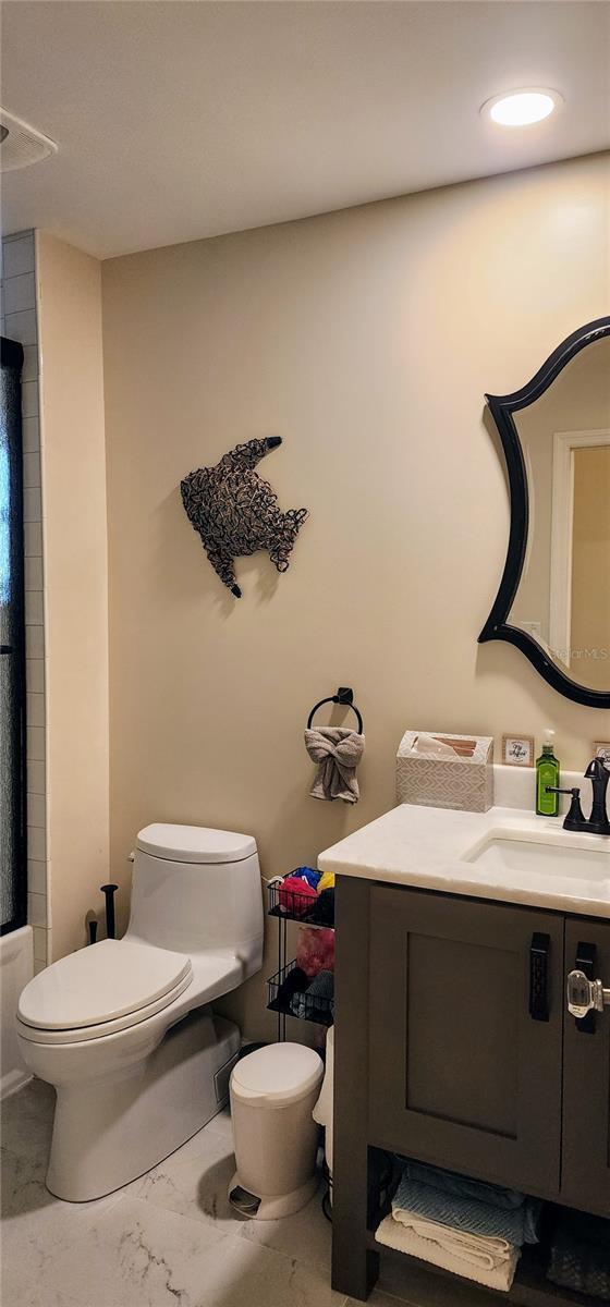 full bath featuring marble finish floor, vanity, and toilet