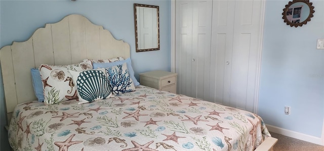 carpeted bedroom featuring a closet and baseboards