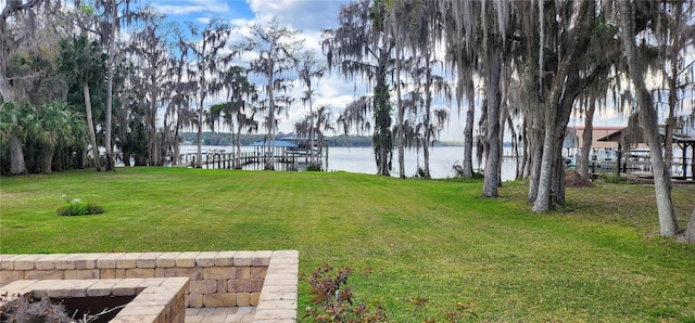 view of yard featuring a boat dock and a water view