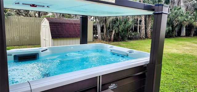 view of pool featuring a lawn, a hot tub, a storage shed, fence, and an outdoor structure