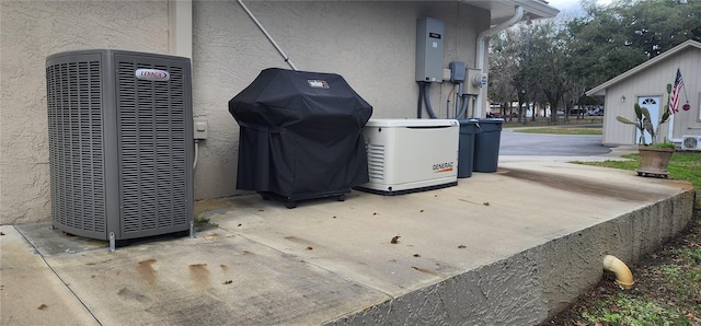 details featuring central air condition unit, a power unit, and stucco siding