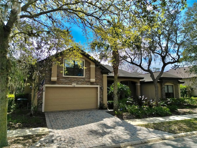 view of front of house with a garage, stone siding, and decorative driveway