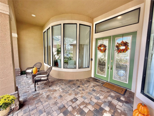 doorway to property featuring a patio and stucco siding