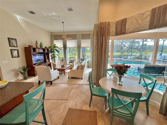 interior space with light tile patterned floors, a sunroom, visible vents, and a ceiling fan