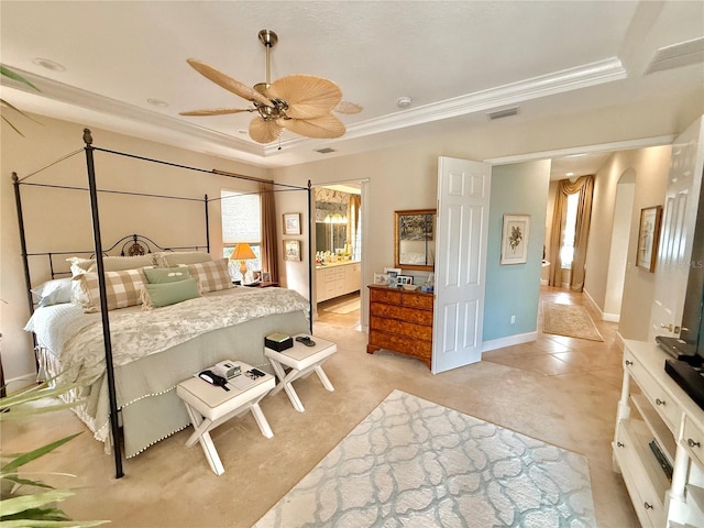 bedroom with arched walkways, a tray ceiling, visible vents, light carpet, and baseboards