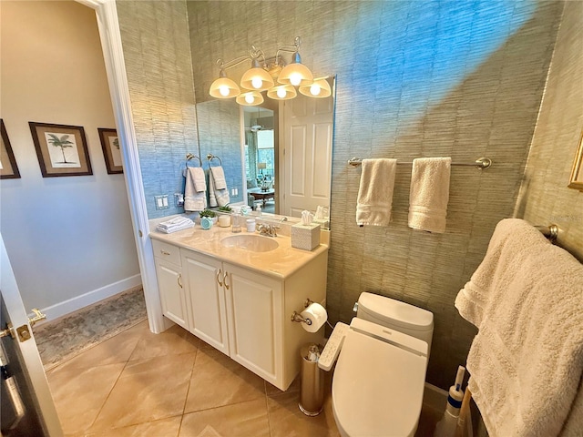 bathroom with a notable chandelier, toilet, vanity, baseboards, and tile patterned floors