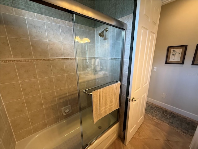 bathroom featuring tile patterned flooring, baseboards, and combined bath / shower with glass door