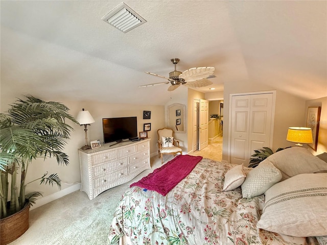 bedroom with carpet floors, visible vents, vaulted ceiling, a textured ceiling, and baseboards