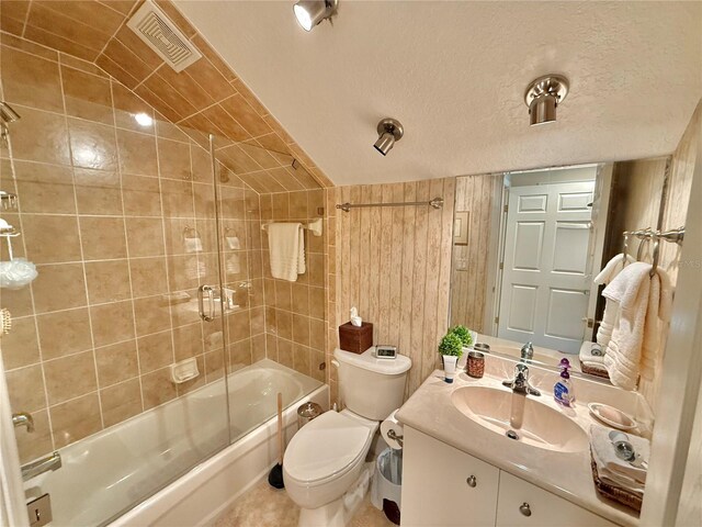 bathroom with enclosed tub / shower combo, a textured ceiling, toilet, visible vents, and vaulted ceiling