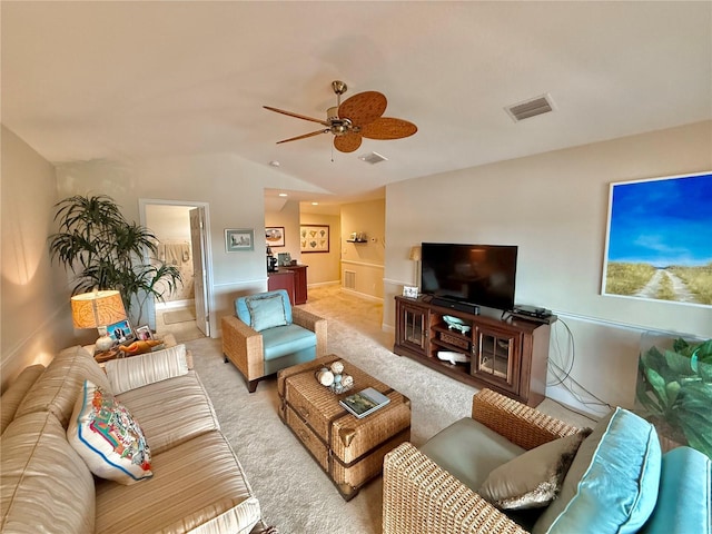 living room featuring ceiling fan, light carpet, visible vents, baseboards, and vaulted ceiling