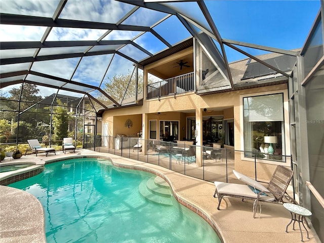 view of swimming pool with a ceiling fan, a lanai, a patio area, and a pool with connected hot tub