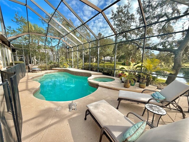 view of swimming pool featuring a patio, a pool with connected hot tub, and glass enclosure