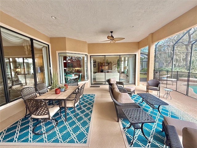 view of patio featuring glass enclosure, ceiling fan, and outdoor lounge area