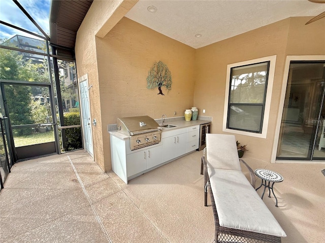 sunroom / solarium with wine cooler, plenty of natural light, and a sink