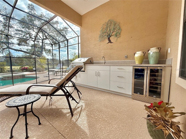 view of patio / terrace featuring wine cooler, a lanai, an in ground hot tub, area for grilling, and a grill