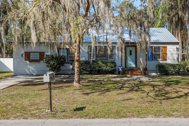 single story home with a front yard and metal roof