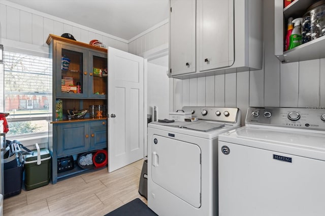 laundry area featuring light wood-type flooring, independent washer and dryer, cabinet space, and crown molding