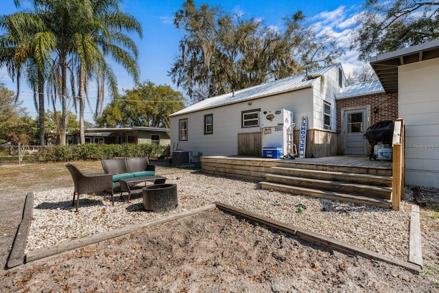 rear view of house featuring outdoor lounge area, metal roof, a wooden deck, and central air condition unit