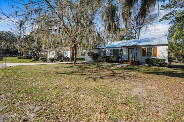 view of front facade featuring a front yard and metal roof