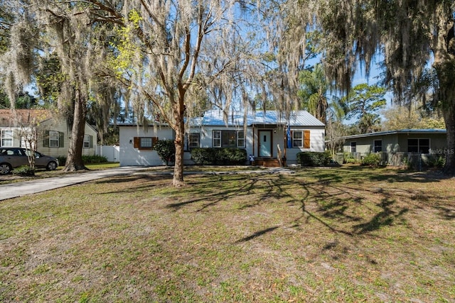 ranch-style house featuring a front lawn and fence