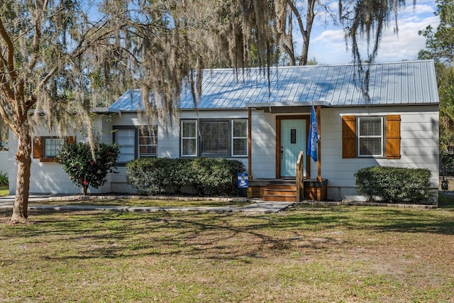 ranch-style house featuring a front yard and metal roof