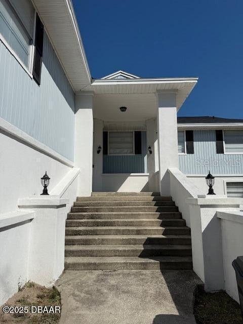 doorway to property featuring stucco siding