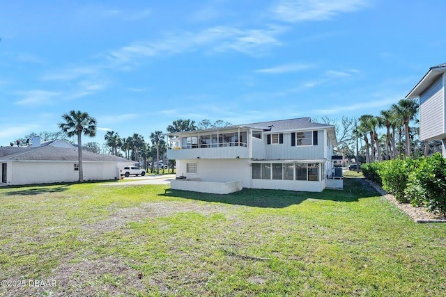 back of house with a lawn and a sunroom